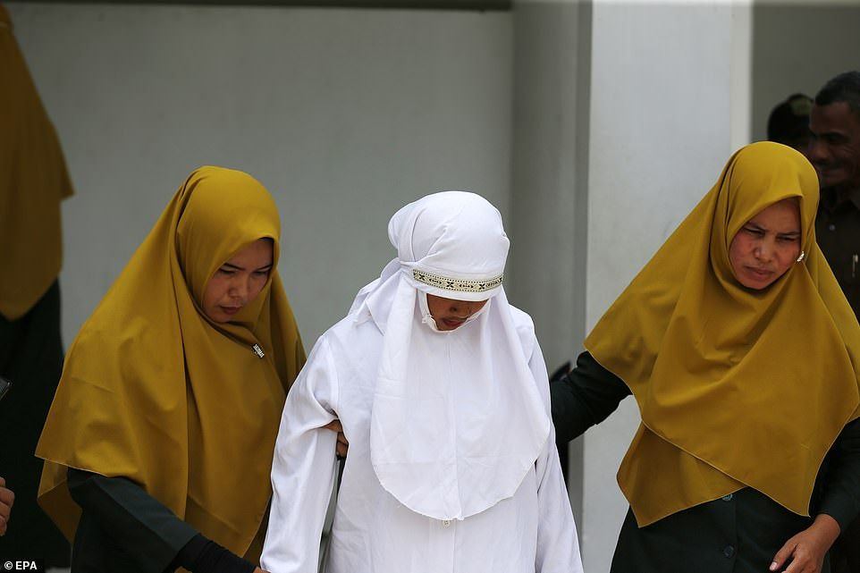 Indonesian woman is caned in public for having sex outside marriage (Photos)