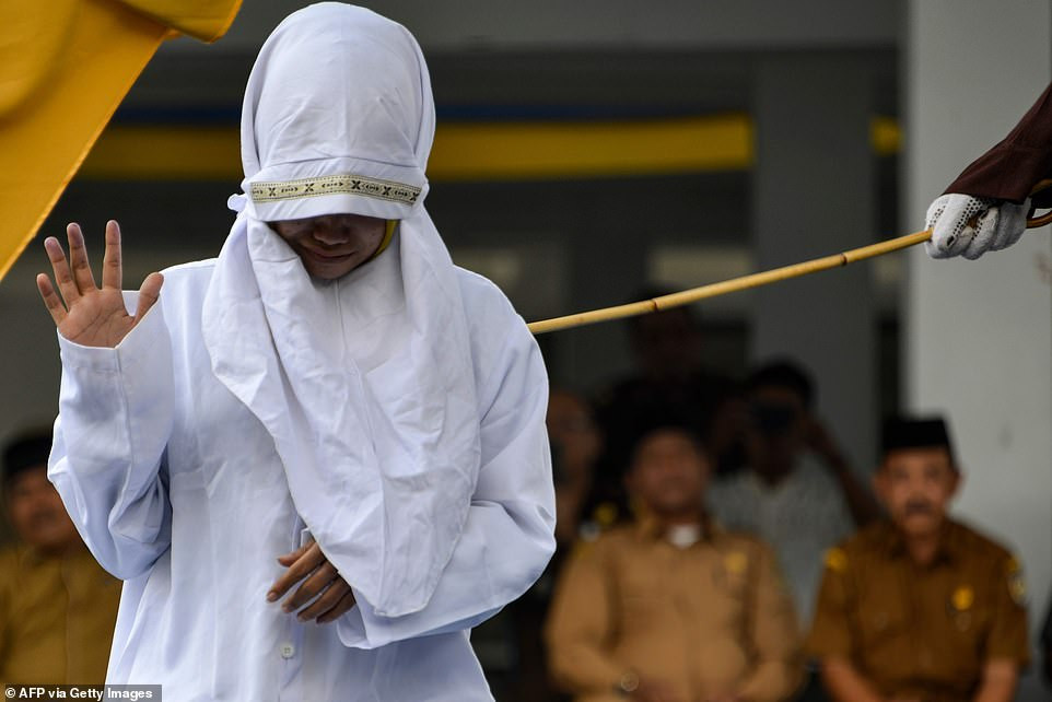 Indonesian woman is caned in public for having sex outside marriage (Photos)