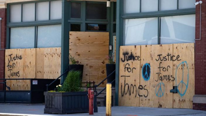 Messages for James Scurlock are spray-painted on boarded-up windows in downtown Omaha. (Z Long/The World-Herald)