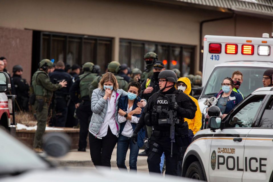 Health care workers walk out of a King Soopers Grocery store after a gunman opened fire on March 22, 2021, in Boulder, Colorado.