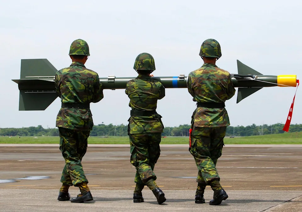 Three troops carrying a missile.