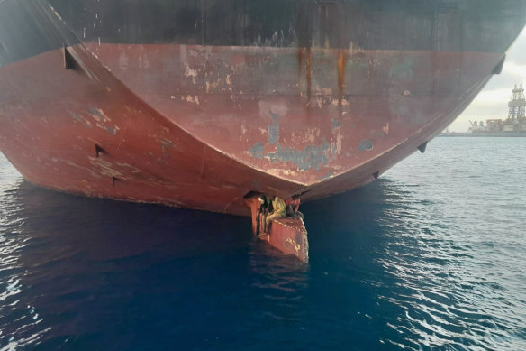 Three men are photographed on an oil tanker anchored in the port of the Canary Islands, Spain.